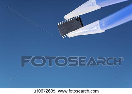 Stock Photography - Microchip held between tweezers.. Fotosearch