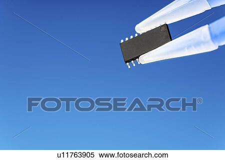 Stock Photography - Microchip held between tweezers.. Fotosearch