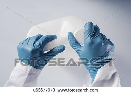 Stock Image - Opening container of hazardous substance.. Fotosearch