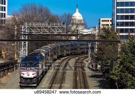 Stock Photo - Passenger train with US Capitol in background approaches L'enfant Plaza Station, Washington D. C.. Fotosearch