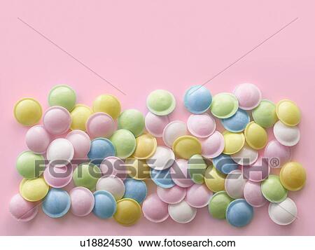 Pastel coloured sweets against a pink background. View Large Photo Image Stock Image - Pastel coloured sweets against a pink background.. Fotosearch