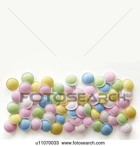 Stock Image - Pastel coloured sweets against a white background.. Fotosearch