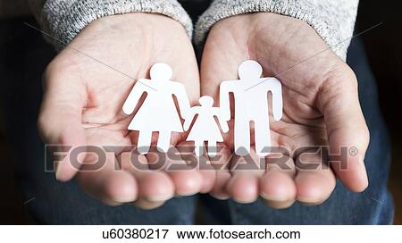 Stock Photo - Person holding paper people in hands.. Fotosearch