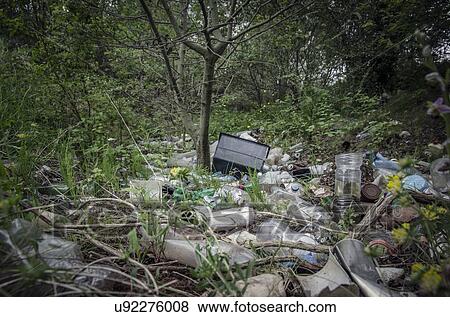 Stock Photo - Piles of refuse, mainly plastic, abandoned amongst trees in urban woodland, West Midlands, UK.. Fotosearch