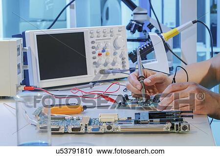 Stock Image - Repairing printed circuit board.. Fotosearch