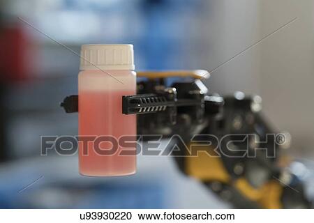 Stock Image - Robotic arm holding bottle.. Fotosearch
