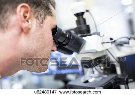 Scientist checking a nanofibre structure under a light microscope. View Large Photo Image Stock Photo - Scientist checking a nanofibre structure under a light microscope.. Fotosearch