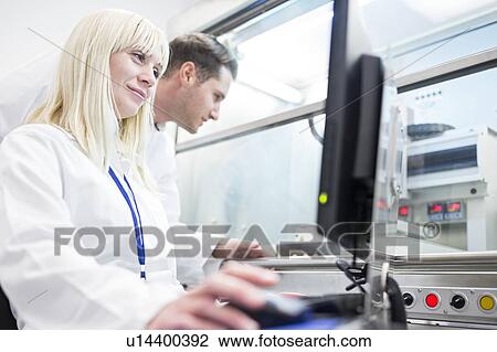 Stock Image - Scientists using a 3D biological printer. The machine can use a range of biomaterial to print tissue-like structures.. Fotosearch
