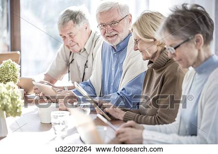Senior adults in care home using digital tablets. View Large Photo Image Picture - Senior adults in care home using digital tablets.. Fotosearch