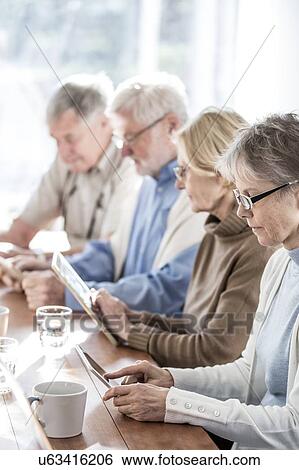 Senior adults in care home using digital tablets. View Large Photo Image Stock Photograph - Senior adults in care home using digital tablets.. Fotosearch