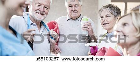 Stock Photo - Senior adults talking to physiotherapist.. Fotosearch