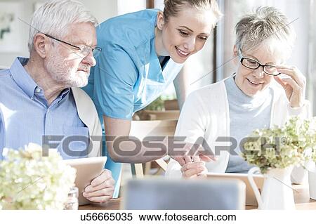 Stock Photography - Senior adults using digital tablets in care home.. Fotosearch