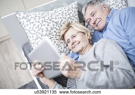 Stock Photography - Senior couple looking at digital tablet.. Fotosearch