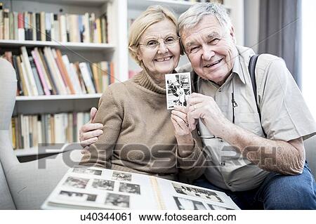 Senior couple looking at photo album. View Large Photo Image Stock Image - Senior couple looking at photo album.. Fotosearch