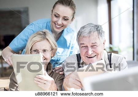 Stock Image - Senior couple using digital tablets in care home.. Fotosearch