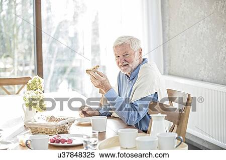 Stock Photography - Senior man eating meal in care home.. Fotosearch