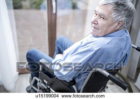 Picture - Senior man in wheelchair by window in care home.. Fotosearch
