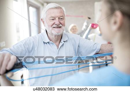 Senior man using resistance band in exercise class. View Large Photo Image Stock Image - Senior man using resistance band in exercise class.. Fotosearch