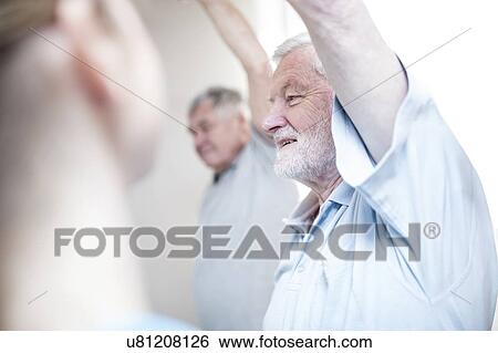 Stock Photograph - Senior men stretching in exercise class.. Fotosearch