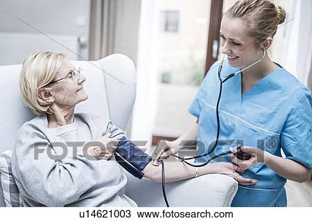 Senior woman having her blood pressure taken by care worker. View Large Photo Image Stock Image - Senior woman having her blood pressure taken by care worker.. Fotosearch