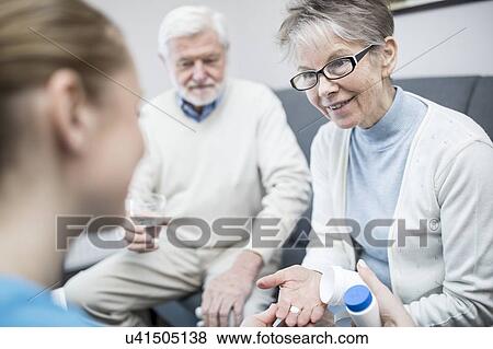 Senior woman holding prescription medication in care home. View Large Photo Image Stock Photo - Senior woman holding prescription medication in care home.. Fotosearch