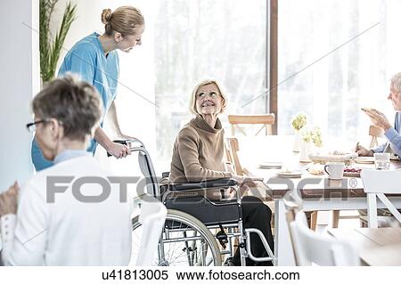 Senior woman in wheelchair smiling towards care worker. View Large Photo Image Stock Photography - Senior woman in wheelchair smiling towards care worker.. Fotosearch
