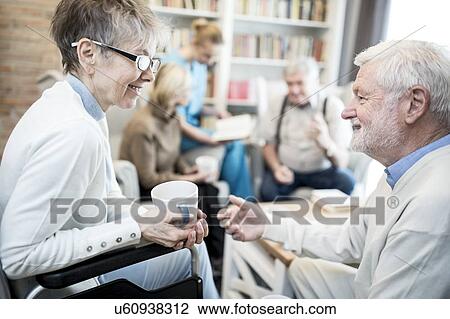 Senior woman in wheelchair talking to male fiend in care home. View Large Photo Image Stock Image - Senior woman in wheelchair talking to male fiend in care home.. Fotosearch