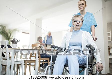 Stock Photo - Senior woman in wheelchair with care worker in care home.. Fotosearch