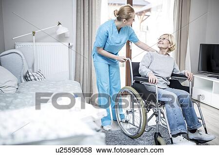 Stock Photo - Senior woman in wheelchair with care worker in care home.. Fotosearch