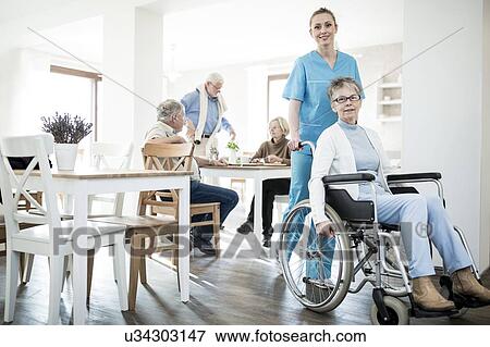 Senior woman in wheelchair with care worker in care home. View Large Photo Image Stock Photo - Senior woman in wheelchair with care worker in care home.. Fotosearch