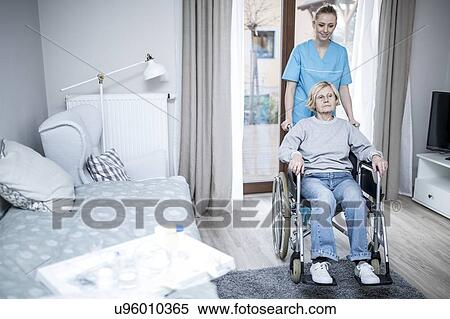 Stock Photography - Senior woman in wheelchair with care worker in care home.. Fotosearch