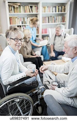 Senior woman in wheelchair with male fiend in care home. View Large Photo Image Stock Image - Senior woman in wheelchair with male fiend in care home.. Fotosearch