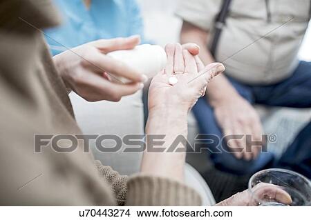 Picture - Senior woman receiving prescription medication in care home.. Fotosearch