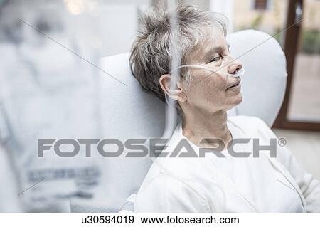 Stock Photo - Senior woman with nasal cannula and IV bag.. Fotosearch