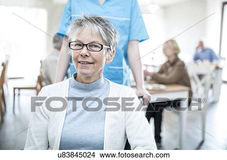 Picture - Senior women smiling towards camera in care home.. Fotosearch