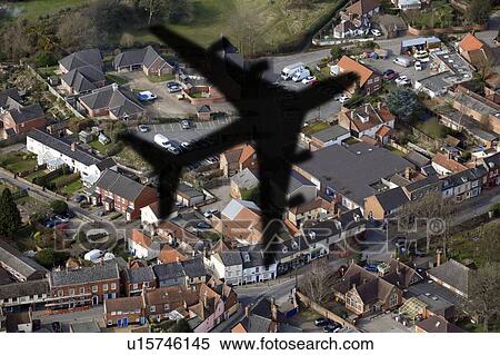Stock Photography - Shadow of an aeroplane flying over houses.. Fotosearch