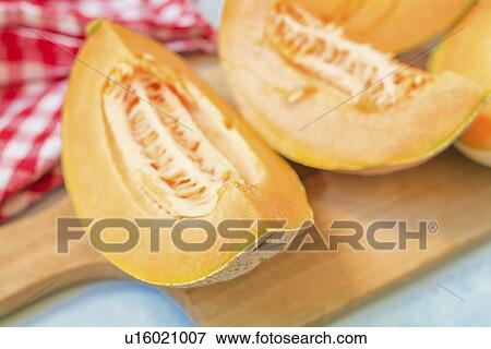 Stock Photo - Slices of cantaloupe melon on rustic table.. Fotosearch