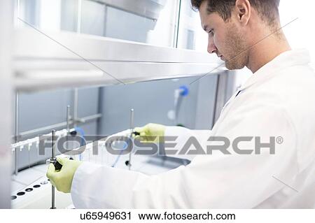 Stock Image - Solid phase extraction (SPE) columns being placed on a stand. SPE is used to separate biological compounds from a mixture for further analysis.. Fotosearch