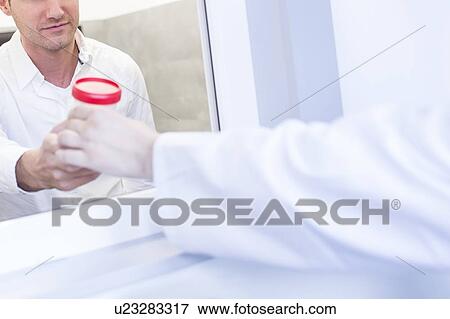 Stock Photo - Sperm sample being handled in a fertility clinic.. Fotosearch