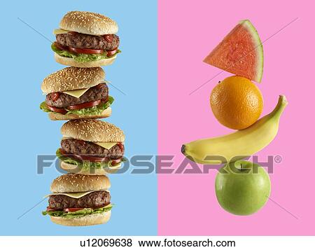 Stock Photo - Stack of hamburgers and stack of fruit.. Fotosearch