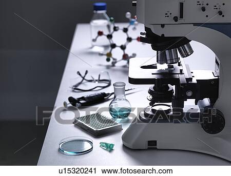 Stock Image - Still life of a laboratory bench with a microscope and various scientific equipment to illustrate research.. Fotosearch