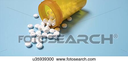 Stock Image - Tablets spilling from container.. Fotosearch