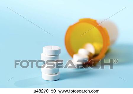 Stock Image - Tablets spilling from container.. Fotosearch