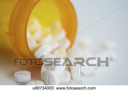 Stock Image - Tablets spilling from container.. Fotosearch