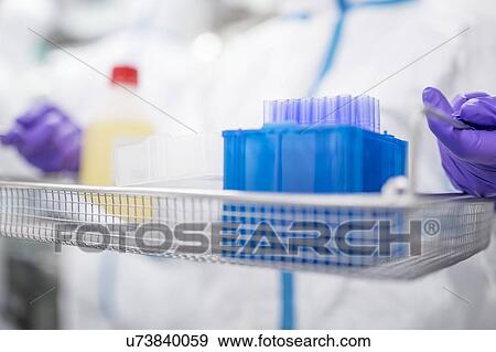 Stock Photo - Technician carrying equipment in a laboratory that manufactures human tissues for implant. Such tissues include bone and skin grafts.. Fotosearch