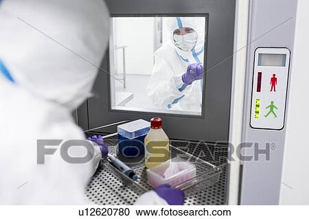 Technician collecting equipment from a transfer hatch in a sterile laboratory that manufactures human tissues for implants. Such implants include bone and skin grafts. View Large Photo Image Stock Image - Technician collecting equipment from a transfer hatch in a sterile laboratory that manufactures human tissues for implants. Such implants include bone and skin grafts.. Fotosearch