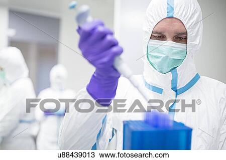 Stock Image - Technician working with cell samples in in a laboratory that engineers human tissues for implant. Such implants include bone and skin grafts.. Fotosearch