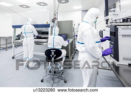 Stock Image - Technicians preparing and checking samples in a laboratory that manufactures human tissues for implant. Such tissues include bone and skin grafts.. Fotosearch