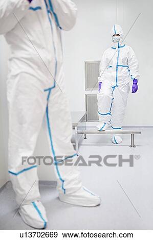 Stock Photo - Technicians walking through a decontamination cabin before entering a sterile laboratory.. Fotosearch