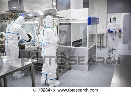 Stock Photography - Technicians working in sealed, sterile isolator units in a laboratory that manufactures human tissues for implant. Such tissues include bone and skin grafts.. Fotosearch